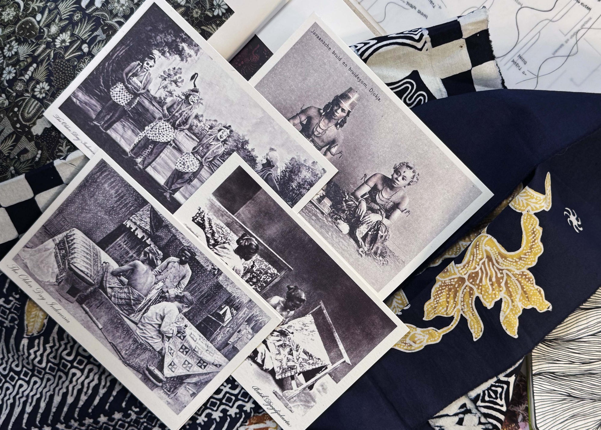 Collection of black and white vintage prints on a textured batik fabric background