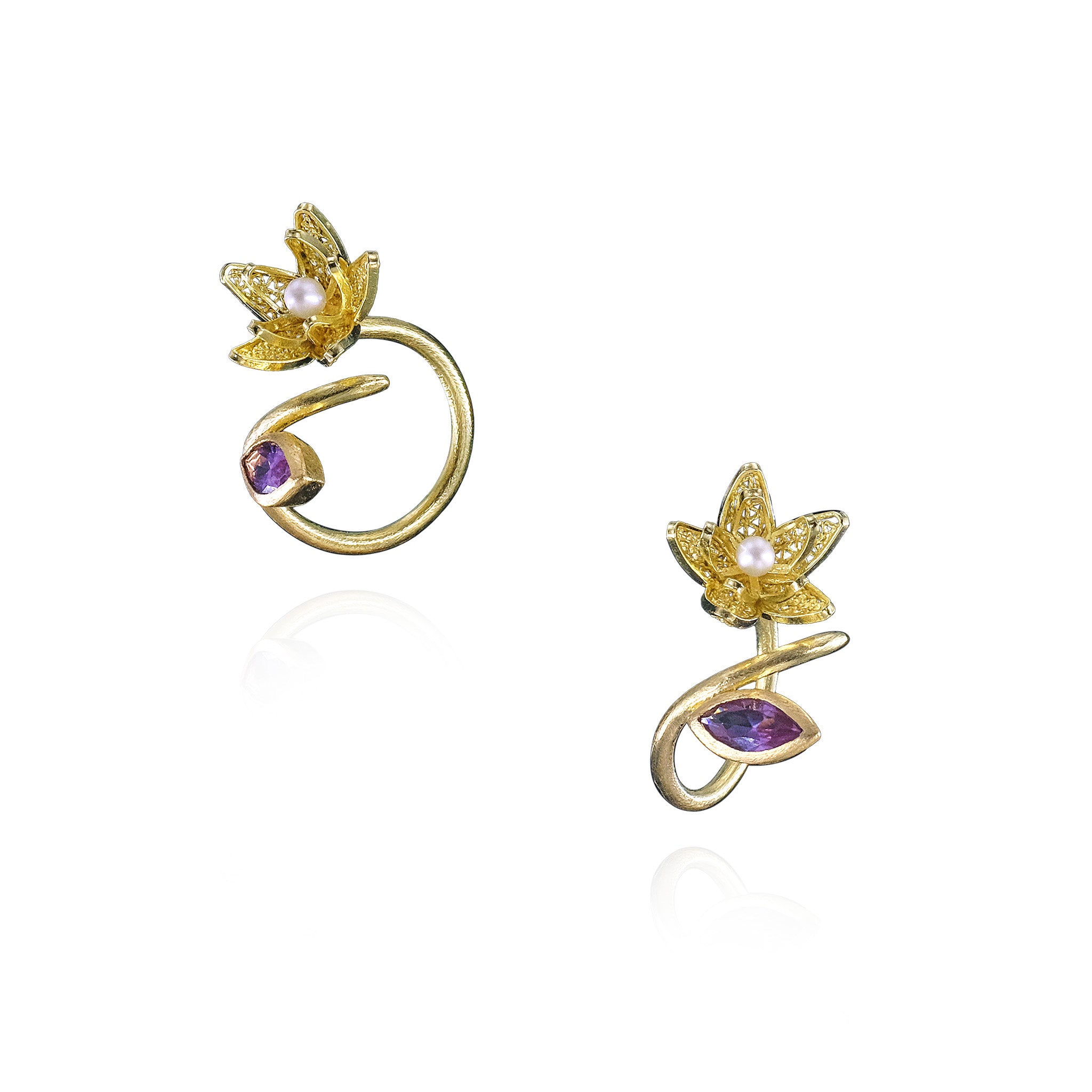 Gold ring with floral design and purple gemstones on a white background