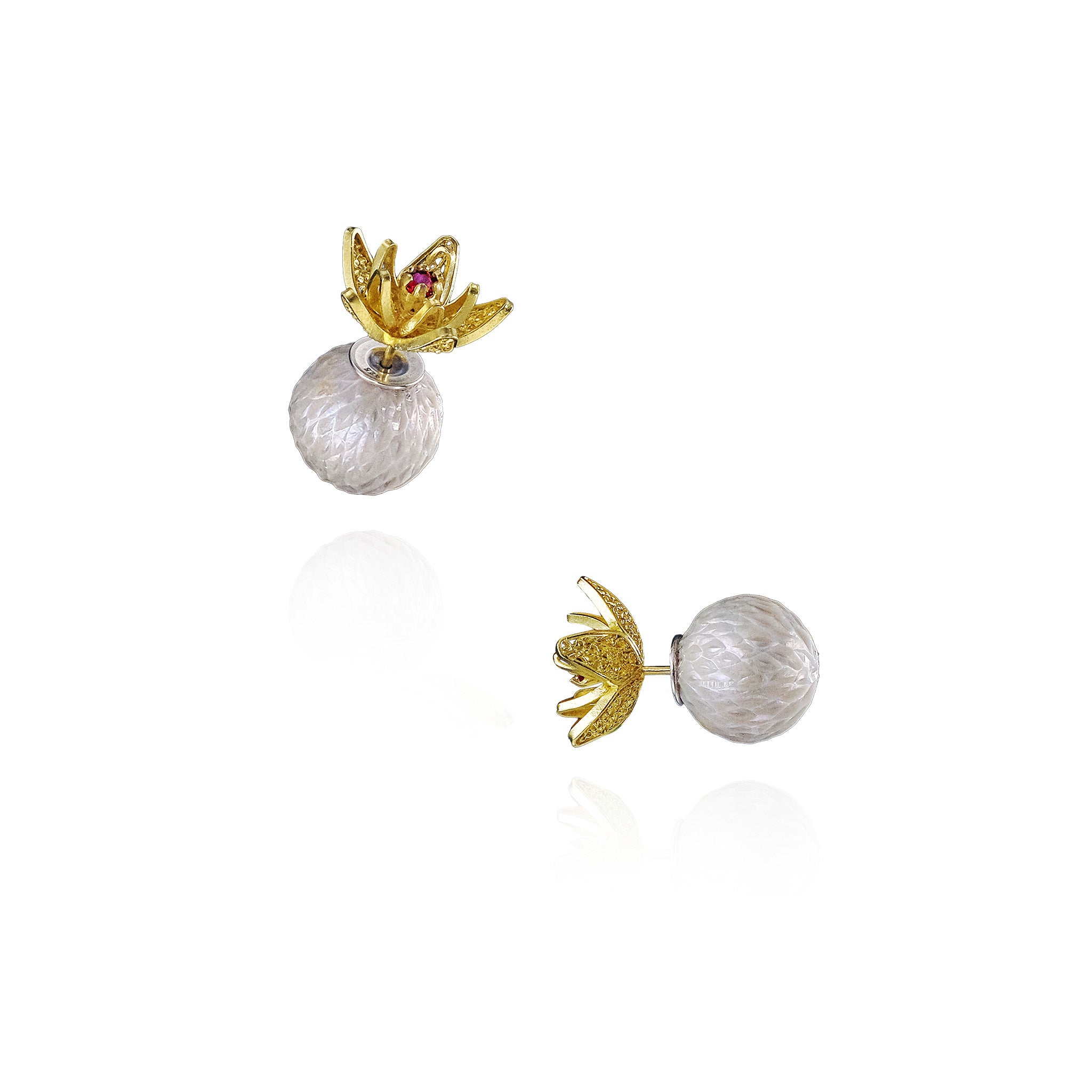 Pair of earrings with gold floral tops and Carved pearl bottoms on a white background