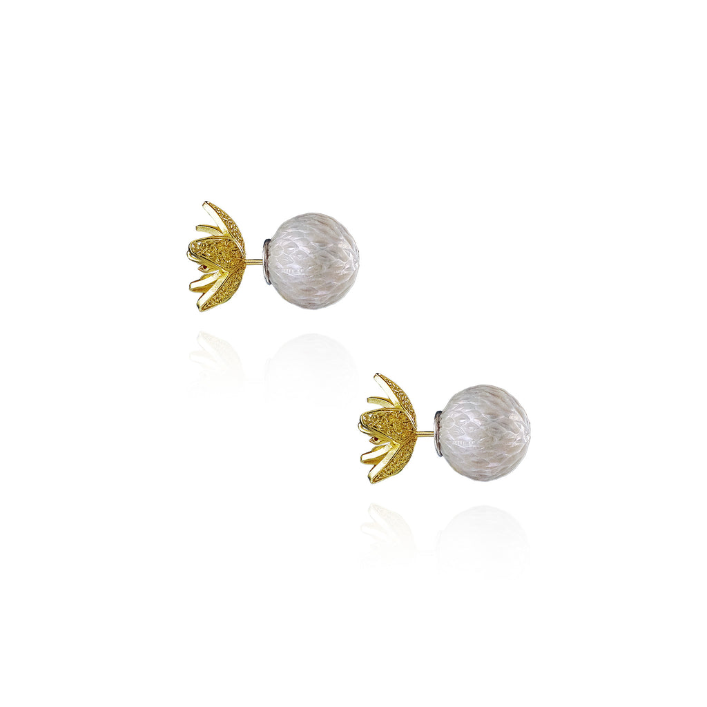 Pair of earrings with gold and white designs on a white background