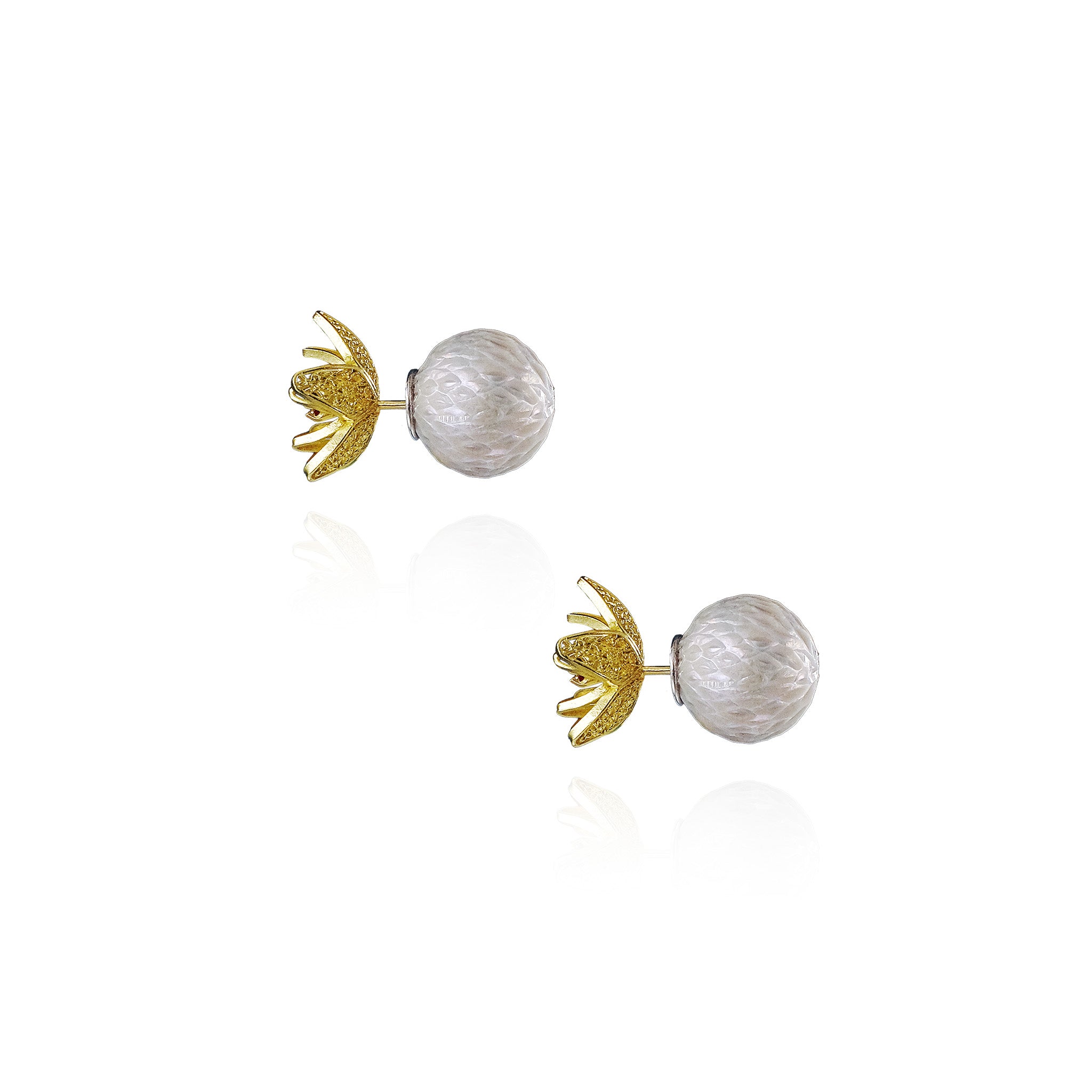 Pair of earrings with gold and white designs on a white background